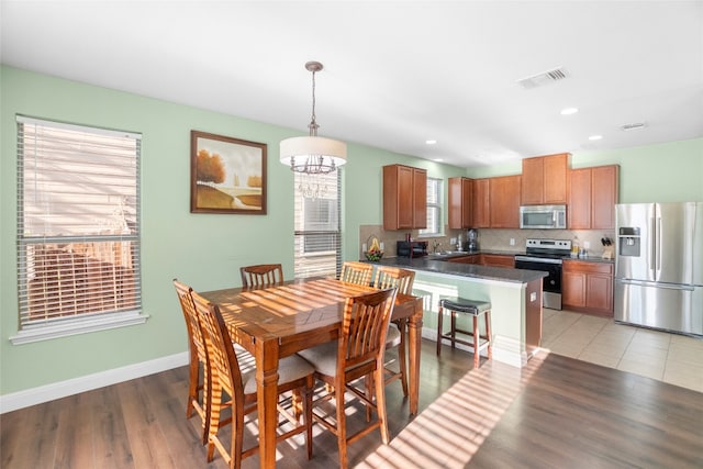 dining area featuring sink, a chandelier, and light hardwood / wood-style floors