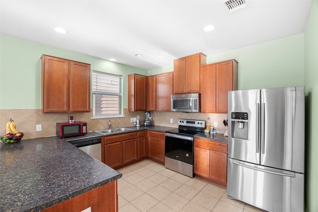 kitchen featuring decorative backsplash, sink, light tile patterned floors, and stainless steel appliances