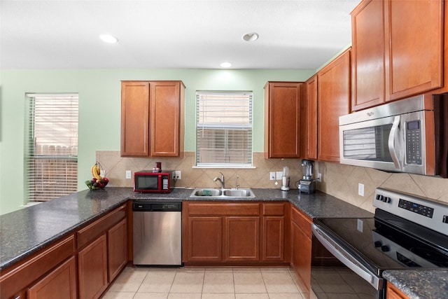 kitchen with decorative backsplash, light tile patterned flooring, sink, and stainless steel appliances