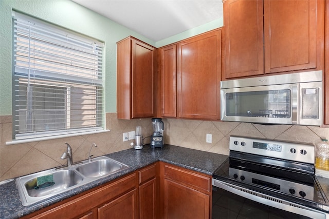 kitchen featuring appliances with stainless steel finishes, a healthy amount of sunlight, decorative backsplash, and sink