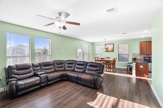 living room featuring dark wood-type flooring and ceiling fan