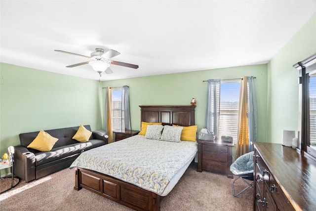 carpeted bedroom with multiple windows and a ceiling fan