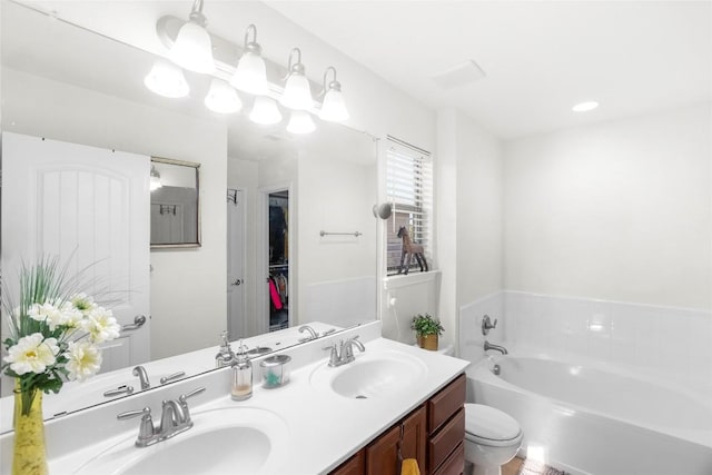 full bathroom with a garden tub, double vanity, a sink, and toilet