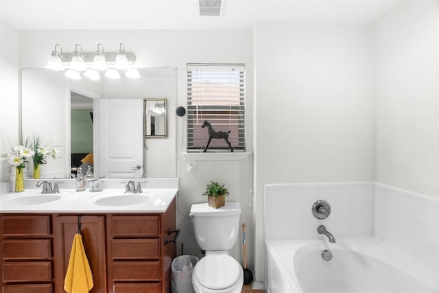 bathroom featuring a tub, toilet, and vanity