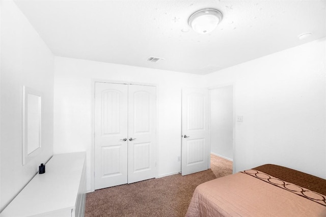 bedroom with a closet, visible vents, and light colored carpet