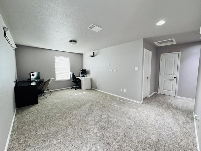 office space with carpet floors, visible vents, baseboards, and a textured ceiling