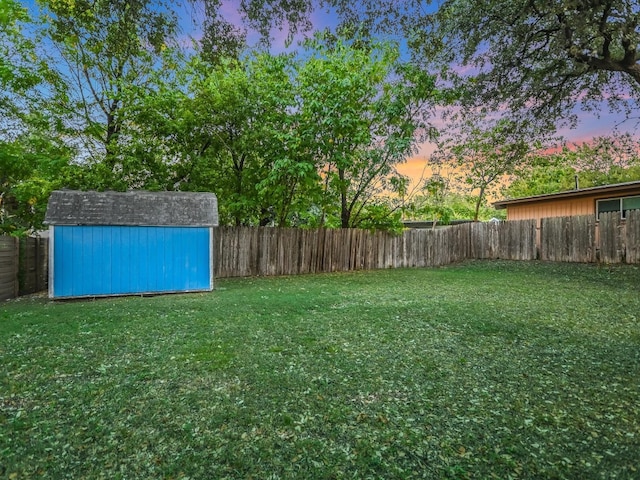 yard at dusk featuring a shed