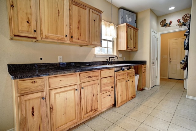 kitchen with light brown cabinetry, light tile patterned flooring, and sink