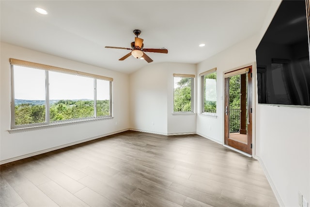 empty room featuring lofted ceiling, ceiling fan, and hardwood / wood-style flooring