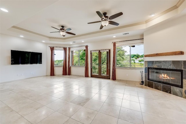 20909 Magellan Cv, Lago Vista, TX 78645 - unfurnished living room featuring a raised ceiling, a tiled fireplace, tile patterned floors, ceiling fan, and recessed lighting