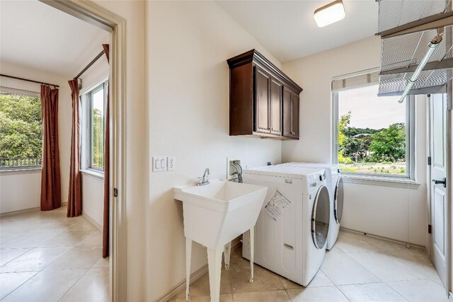 20909 Magellan Cv, Lago Vista, TX 78645 - washroom featuring separate washer and dryer, cabinet space, and light tile patterned floors