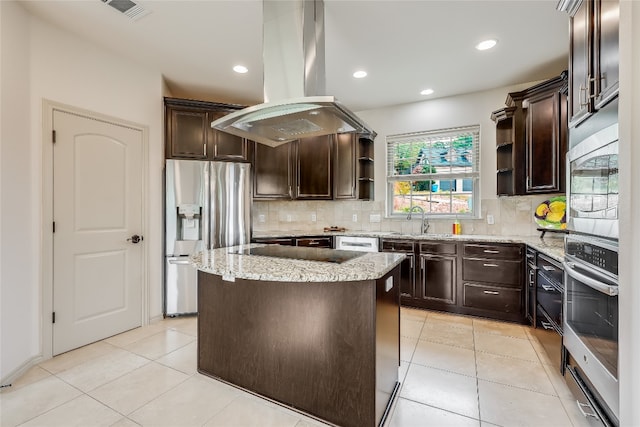 kitchen with island exhaust hood, a kitchen island, backsplash, appliances with stainless steel finishes, and dark brown cabinetry