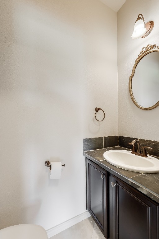 bathroom featuring tile patterned flooring, vanity, and toilet