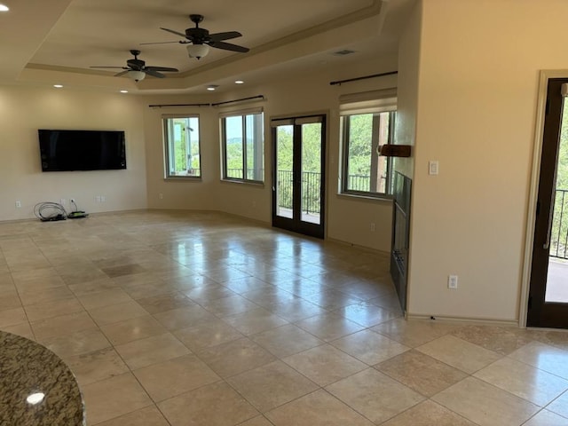 20909 Magellan Cv, Lago Vista, TX 78645 - empty room featuring a raised ceiling, light tile patterned floors, baseboards, healthy amount of natural light, and recessed lighting