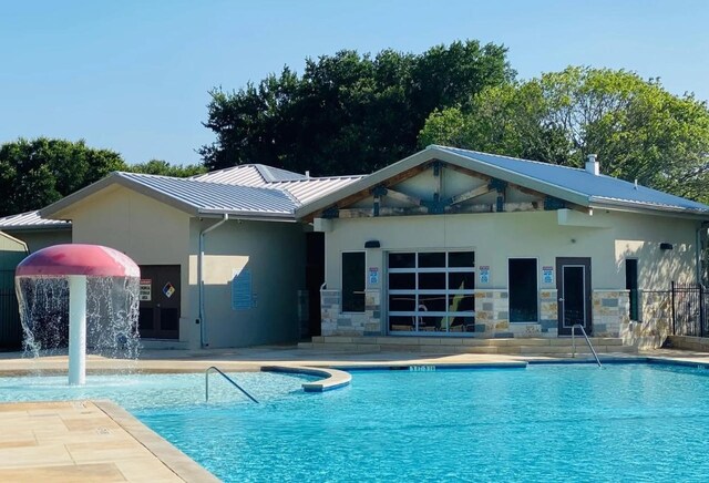 view of swimming pool featuring pool water feature and a patio area