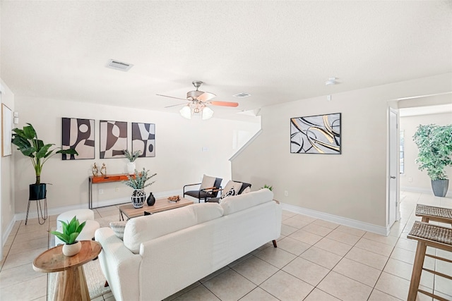 tiled living room featuring ceiling fan and a textured ceiling