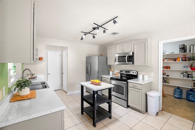 kitchen featuring a textured ceiling, appliances with stainless steel finishes, and sink