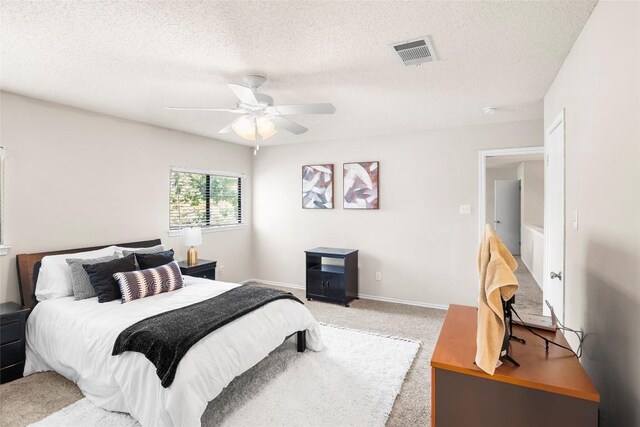 carpeted bedroom with a textured ceiling and ceiling fan