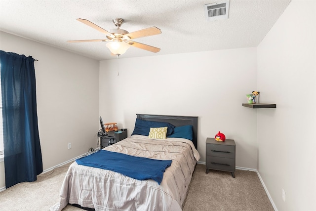 bedroom featuring a textured ceiling, ceiling fan, and light colored carpet