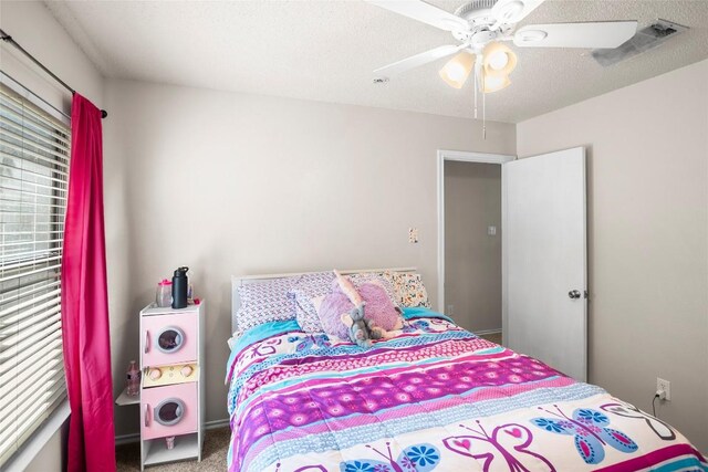 bedroom featuring ceiling fan, carpet flooring, and a textured ceiling