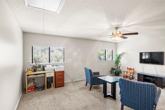 interior space featuring ceiling fan, a textured ceiling, and light carpet