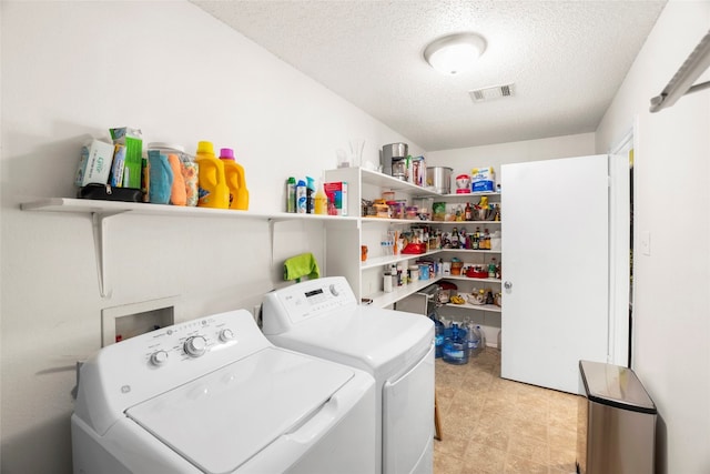 laundry room featuring a textured ceiling and separate washer and dryer