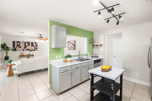 kitchen with ceiling fan, sink, a textured ceiling, gray cabinets, and appliances with stainless steel finishes