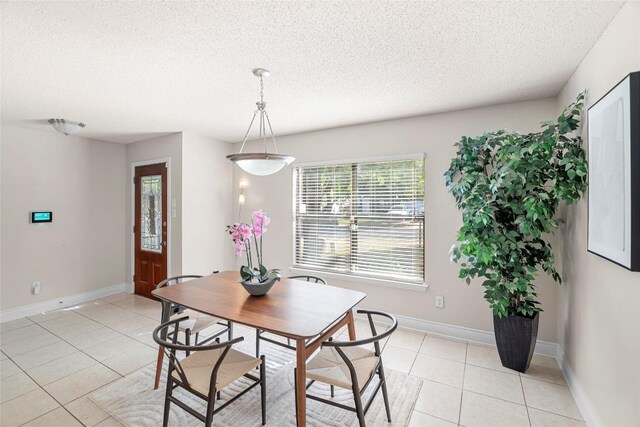 dining area featuring a textured ceiling and light tile patterned floors