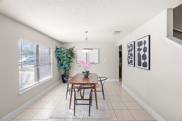 tiled dining area featuring a textured ceiling