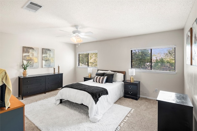 carpeted bedroom with a textured ceiling and ceiling fan