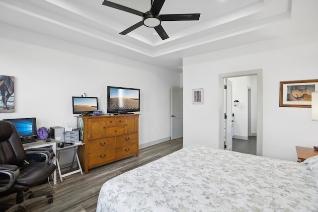 bedroom featuring a tray ceiling, ceiling fan, and dark hardwood / wood-style floors