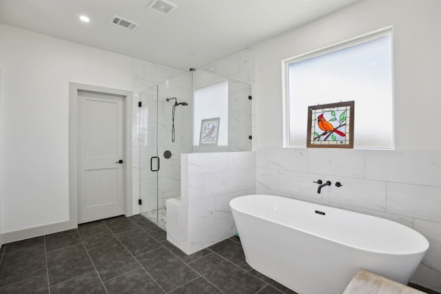 bathroom featuring separate shower and tub, tile walls, and tile patterned floors