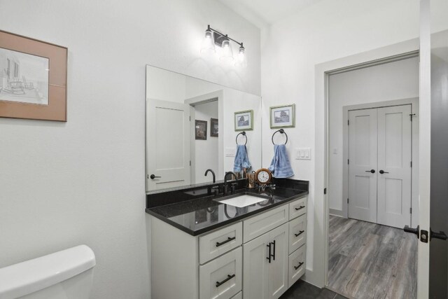 bathroom featuring hardwood / wood-style flooring, vanity, and toilet