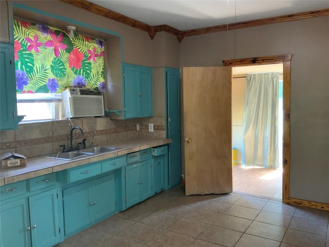 kitchen featuring blue cabinetry, tile countertops, crown molding, and sink