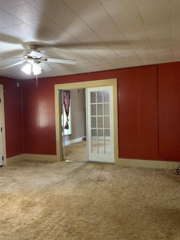 unfurnished room with ceiling fan and carpet floors