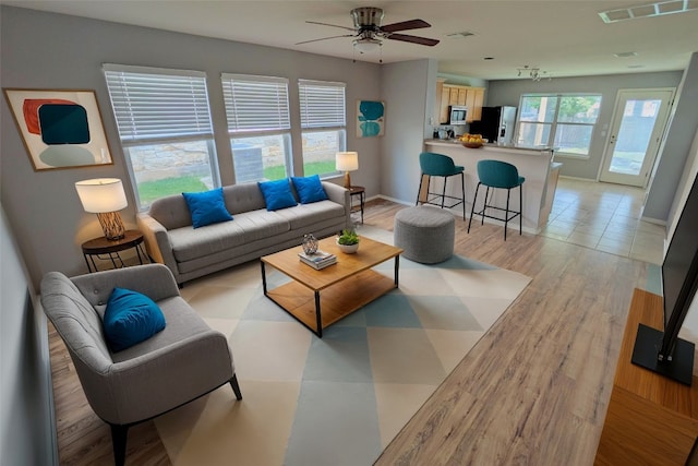 living room with light hardwood / wood-style floors and ceiling fan