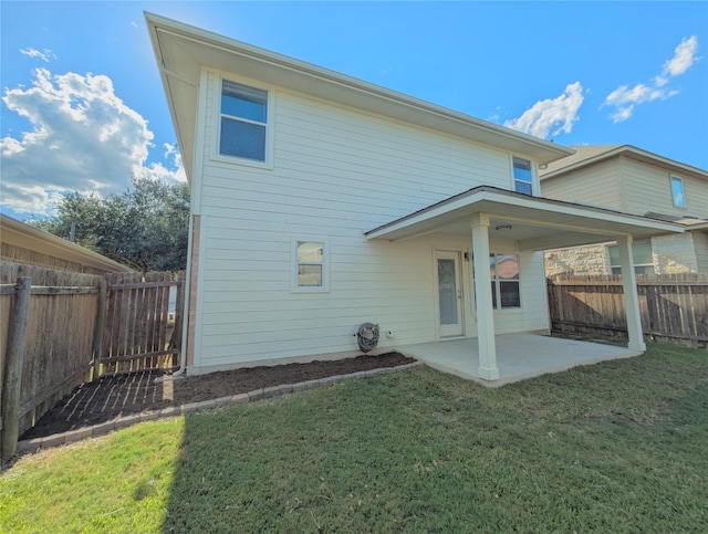 rear view of property featuring a lawn and a patio