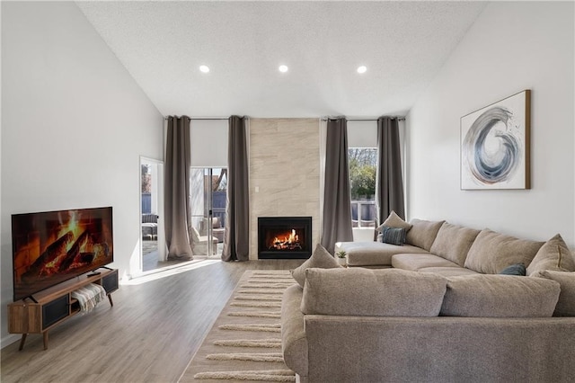 living room with a textured ceiling, a fireplace, and hardwood / wood-style floors