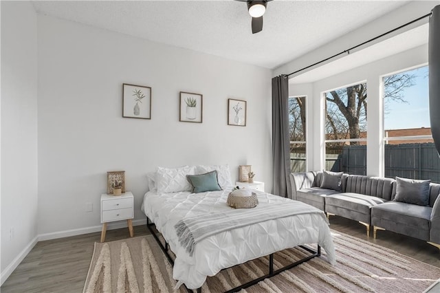 bedroom featuring ceiling fan, a textured ceiling, and dark hardwood / wood-style floors