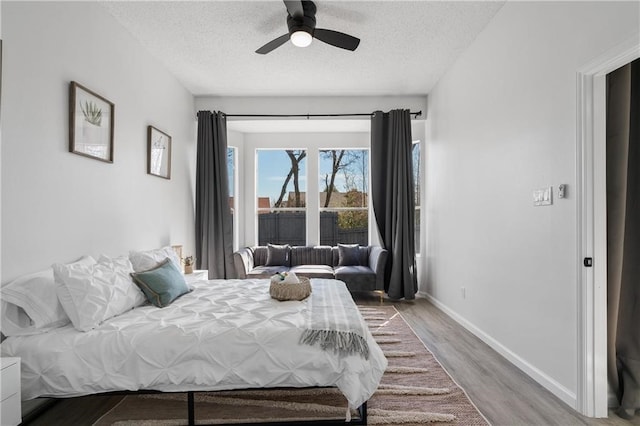 bedroom with ceiling fan, hardwood / wood-style floors, and a textured ceiling