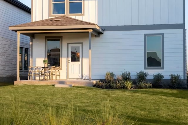 view of exterior entry featuring a yard and a patio area