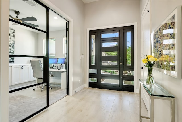 entrance foyer featuring light wood-type flooring, ceiling fan, and plenty of natural light