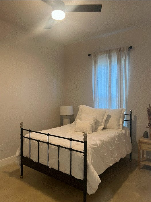 bedroom with light carpet and ceiling fan