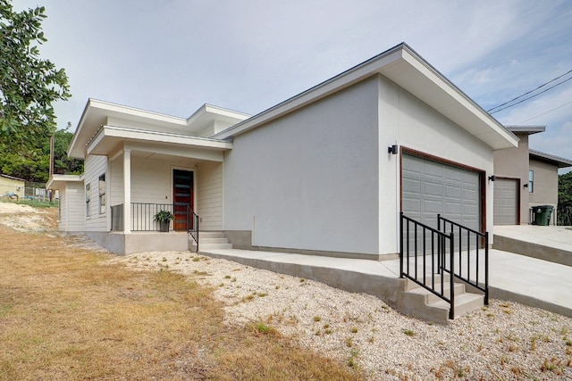 view of side of property featuring a garage and a porch