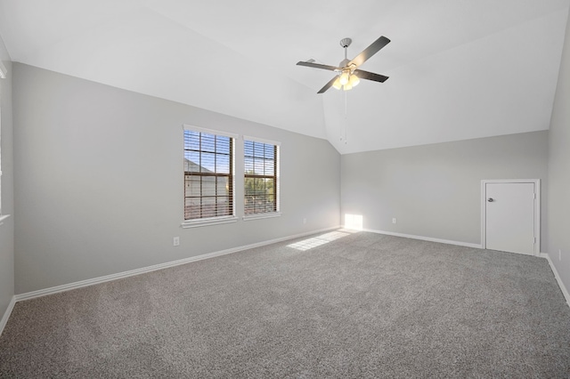 empty room featuring vaulted ceiling, ceiling fan, and carpet flooring