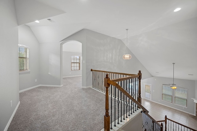 corridor featuring light colored carpet and lofted ceiling