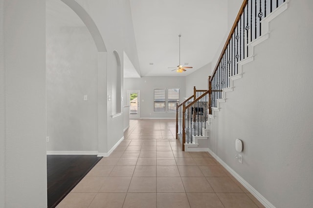 tiled foyer entrance with a towering ceiling and ceiling fan