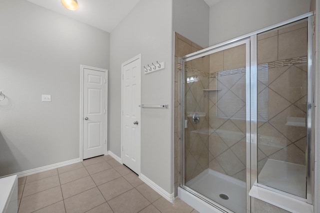 bathroom with a shower with shower door and tile patterned flooring