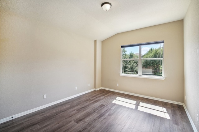 unfurnished room with dark hardwood / wood-style floors and vaulted ceiling