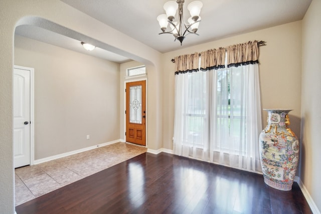 entryway with wood-type flooring and a notable chandelier